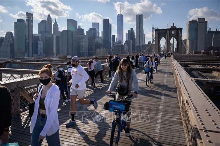 Người dân di chuyển trên cầu Brooklyn ở New York, Mỹ, ngày 25-4-2021. Ảnh: AFP/TTXVN