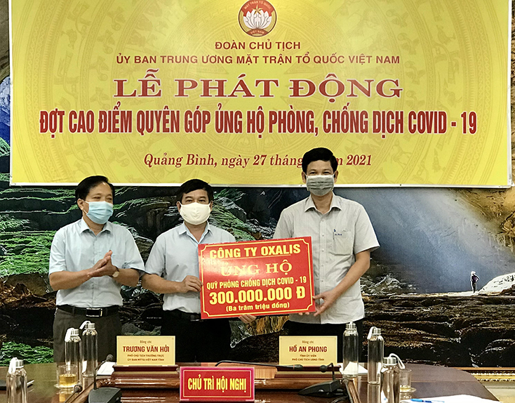 Đồng chí Phó Chủ tịch UBND tỉnh Hồ An Phong và đại diện lãnh đạo Ủy ban MTTQVN tỉnh tiếp nhận số tiền ủng hộ 300 triệu đồng từ Công ty Oxalis. 