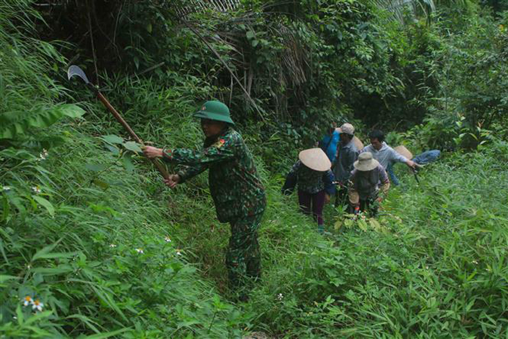 Bộ đội Biên phòng Đồn Biên phòng Thị Hoa (huyện Hạ Lạng, tỉnh Cao Bằng) và người dân tham gia phát quang đường tuần tra biên giới. Ảnh: Chu Hiệu/TTXVN