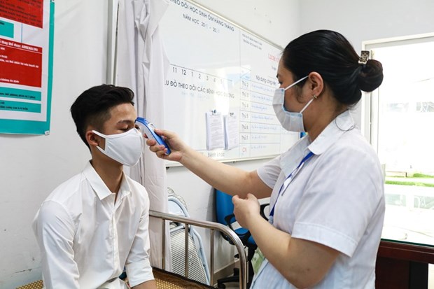 Cán bộ y tế kiểm tra sức khỏe cho thí sinh trong kỳ thi. (Ảnh: Nguyên An/Vietnam+)