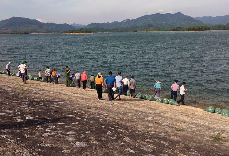 Người dân huyện Quảng Ninh thả cá giống vào môi trường tự nhiên tại đập Rào Đá, xã Trường Xuân.