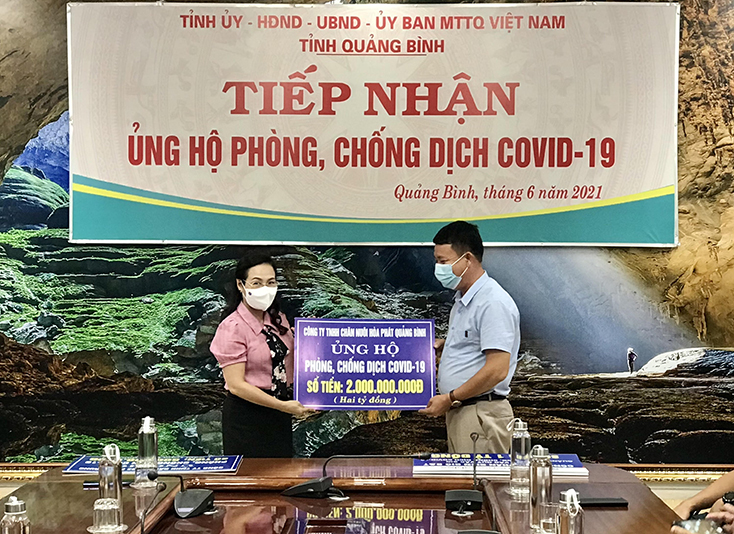 Đồng chí Chủ tịch Ủy ban MTTQVN tỉnh Phạm Thị Hân tiếp nhận số tiền ủng hộ từ Công ty TNHH chăn nuôi Hòa Phát Quảng Bình. 