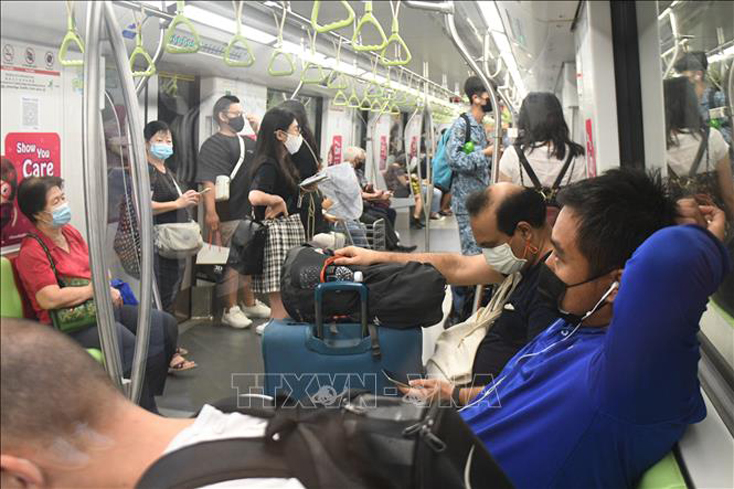 Người dân đeo khẩu trang phòng dịch COVID-19 trên tàu điện ngầm tại Singapore. Ảnh: THX/TTXVN