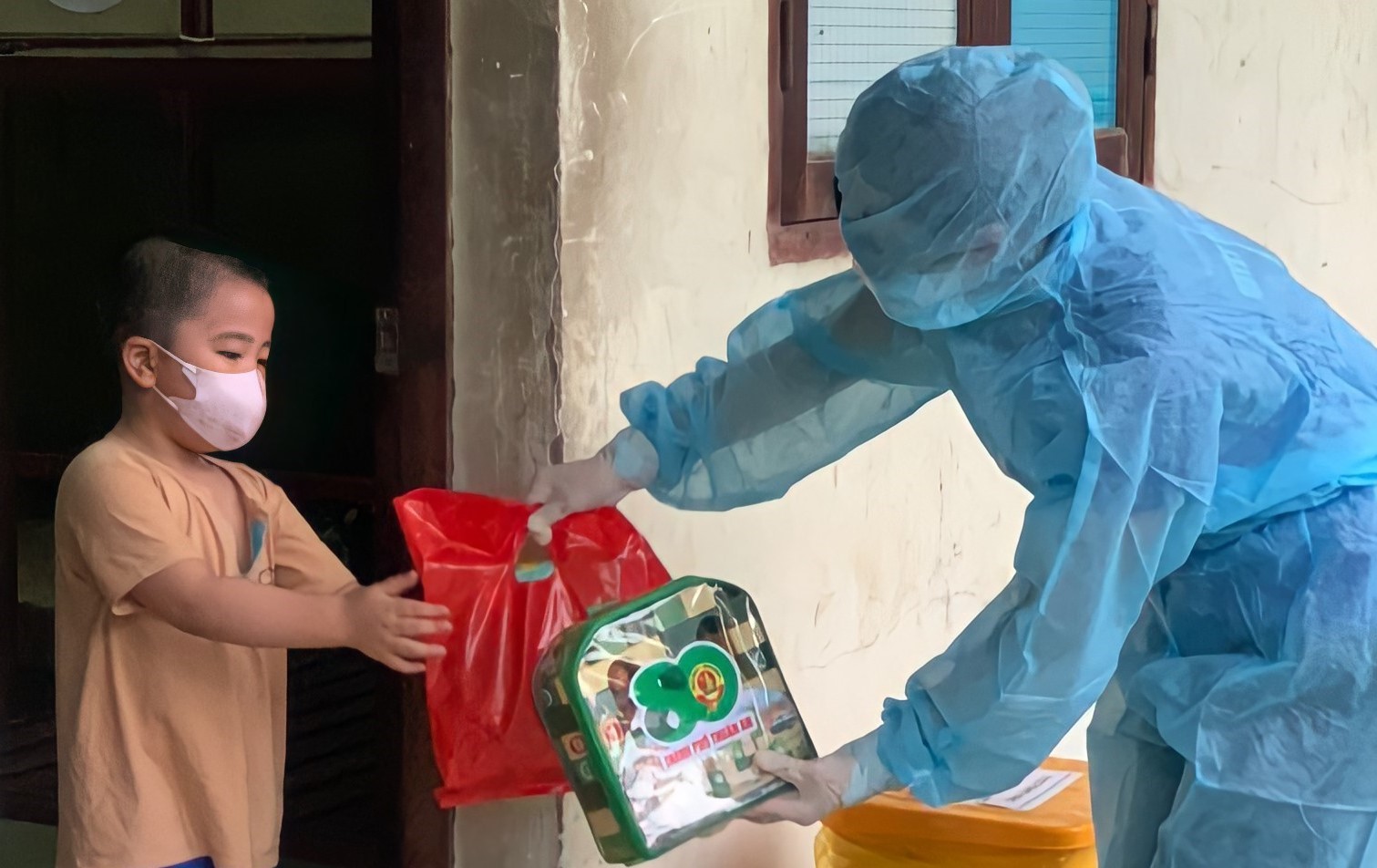  Các thanh niên tình nguyện trao quà Tết thiếu nhi cho các trẻ em trong khu cách ly tại Thuận An (Bình Dương). Ảnh: TTXVN.