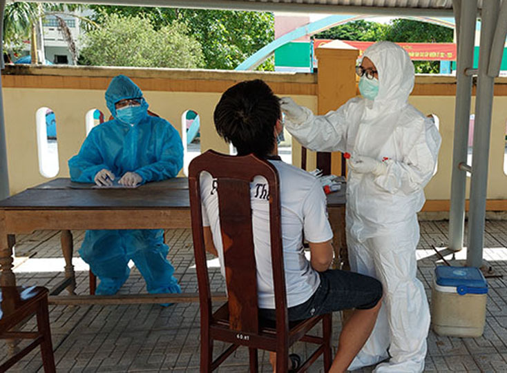 Cán bộ y tế lấy mẫu xét nghiệm SARS-CoV-2 cho công dân tại Khu cách ly tập trung huyện Bố Trạch.