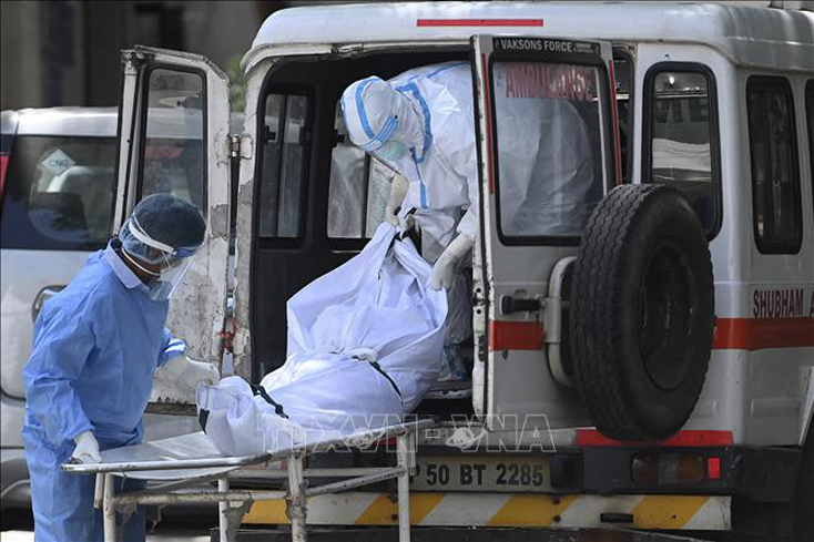 Nhân viên y tế chuyển bệnh nhân tử vong do COVID-19 tới nhà xác ở New Delhi, Ấn Độ, ngày 24-5-2021. Ảnh: AFP/TTXVN