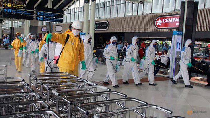 Nhân viên khử trùng làm nhiệm vụ tại sân bay quốc tế Soekarno-Hatta gần Jakarta, Indonesia. Ảnh: Reuters
