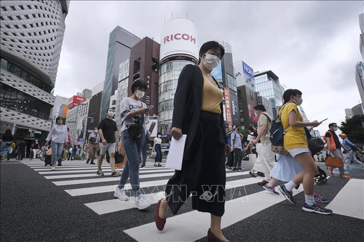 Người dân di chuyển trên đường phố tại Tokyo, Nhật Bản, ngày 25-7-2020. Ảnh: AFP/TTXVN