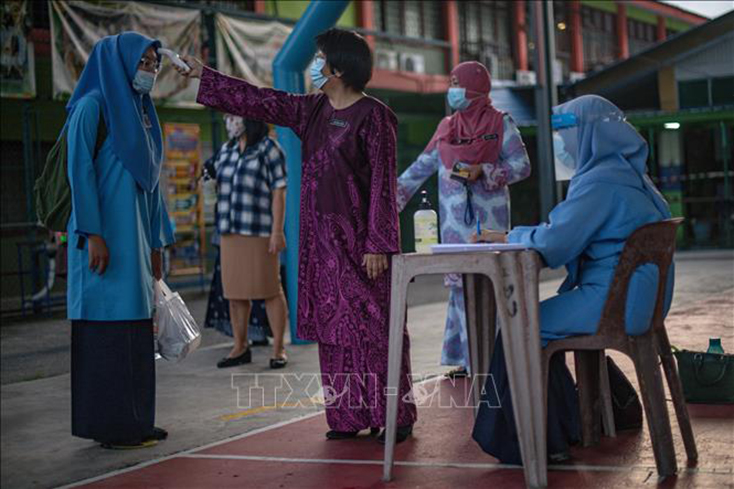 Kiểm tra thân nhiệt phòng lây nhiễm COVID-19 tại một trường học ở Kuala Lumpur, Malaysia. Ảnh: AFP/TTXVN