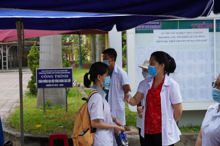 Lực lượng y tế đo thân nhiệt thí sinh trước khi vào điểm thi Trường THPT chuyên Võ Nguyên Giáp.