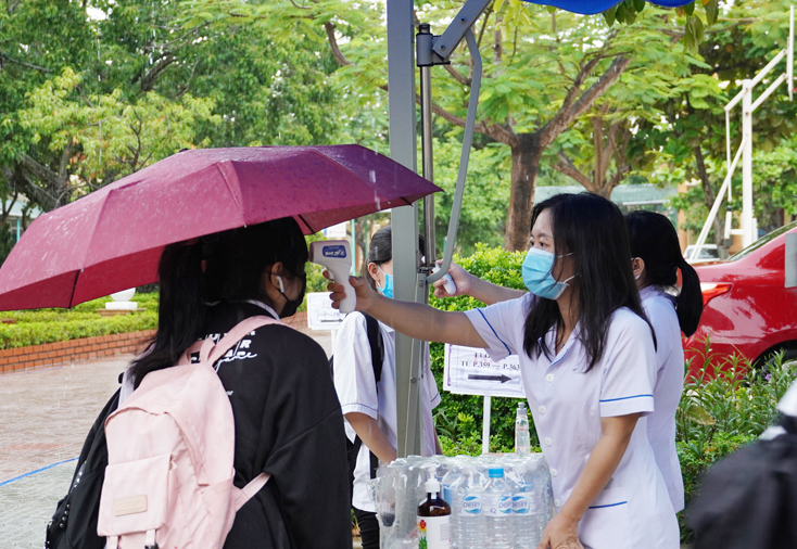Cán bộ Y tế tại điểm thi Trường THPT Phan Đình Phùng đo thân nhiệt cho thí sinh trước khi vào trường thi.