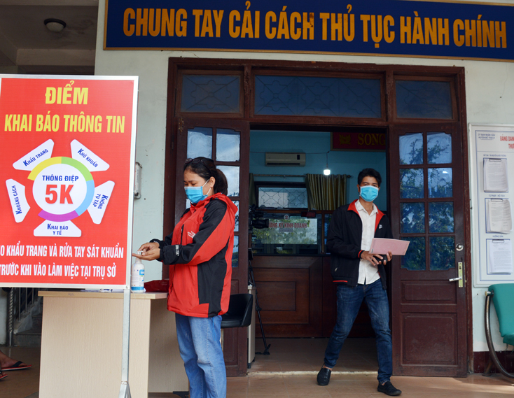 Người dân thực hiện các bước phòng chống dịch bệnh khi đến làm việc tại bộ phận giao dịch một cửa huyện Bố Trạch.