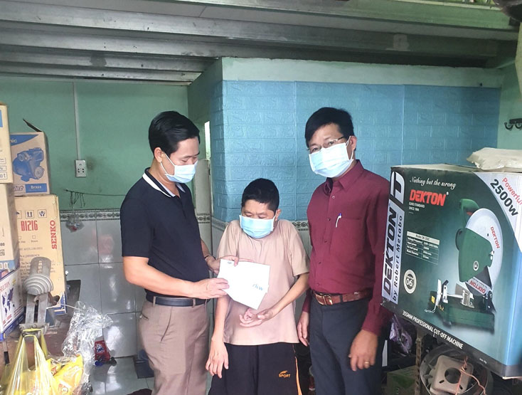 Đại diện Ban Cứu trợ HĐH Quảng Bình tại TP.HCM, trao quà cho bà con bị bệnh tật. Ảnh: HĐH 