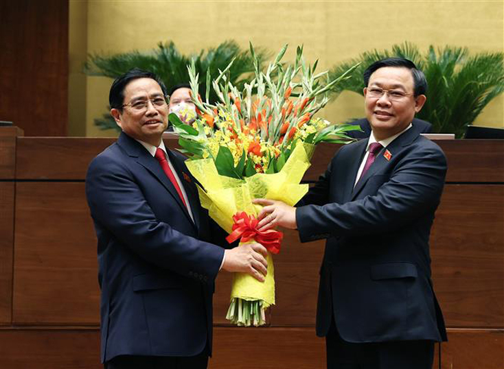 Chủ tịch Quốc hội Vương Đình Huệ tặng hoa chúc mừng Thủ tướng Phạm Minh Chính. Ảnh: Dương Giang/TTXVN