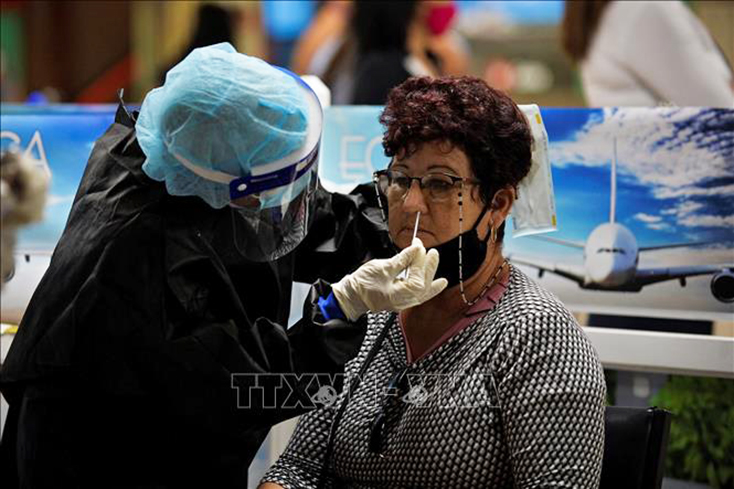  Nhân viên y tế lấy mẫu xét nghiệm COVID-19 cho hành khách tại sân bay quốc tế Jose Marti ở Havana, Cuba ngày 15-11-2020. Ảnh tư liệu: AFP/TTXVN