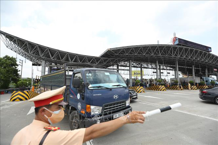 Lực lượng chức năng hướng dẫn các phương tiện lưu thông tại khu vực trạm thu phí Pháp Vân - Cầu Giẽ. Ảnh: Minh Quyết/TTXVN