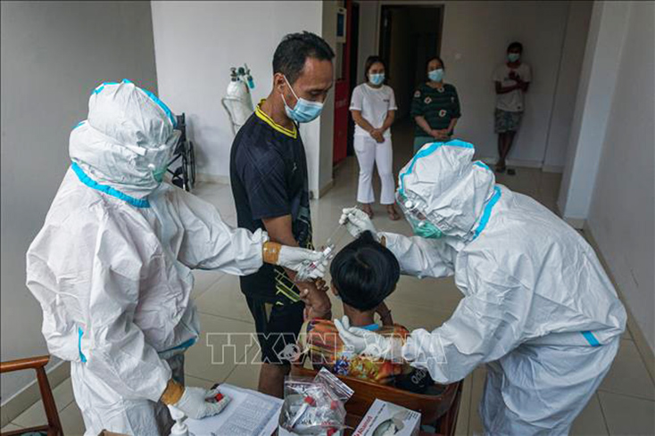 Nhân viên y tế lấy mẫu xét nghiệm COVID-19 cho người dân tại Bali, Indonesia ngày 27-7-2021. Ảnh: THX/TTXVN