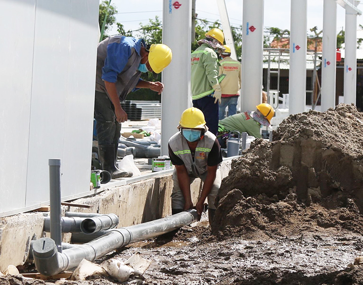 Lắp đặt hệ thống đường ống dẫn nước sạch tại bệnh viện dã chiến trên đường Nguyễn Văn Linh (TP Hồ Chí Minh). Ảnh: Trần Xuân Tình/TTXVN.