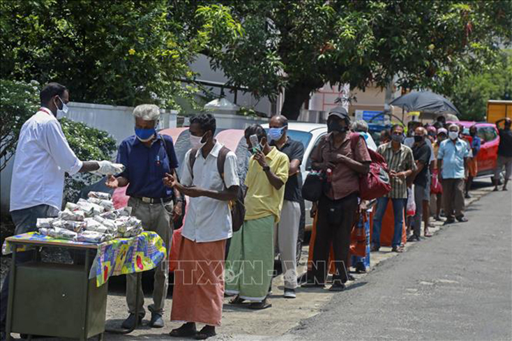 Người dân xếp hàng chờ nhận thực phẩm cứu trợ do dịch COVID-19 tại Kochi, bang Kerala, Ấn Độ. Ảnh: AFP/TTXVN
