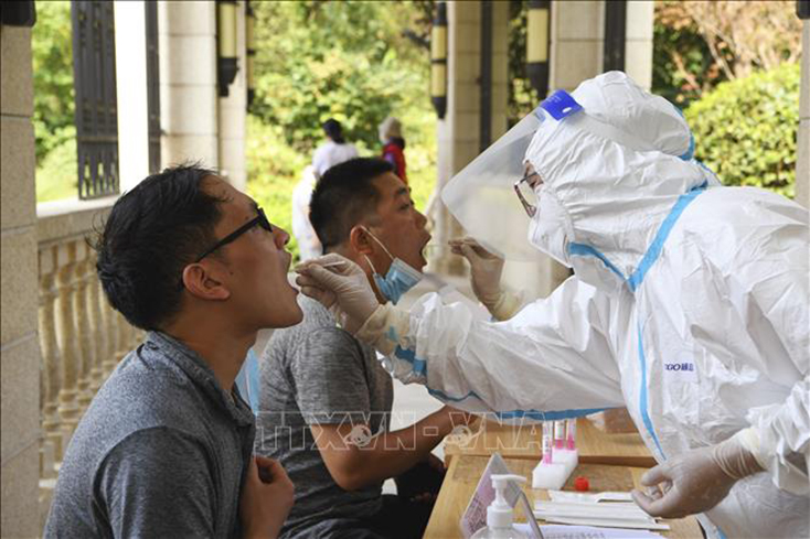 Nhân viên y tế lấy mẫu xét nghiệm COVID-19 cho người dân tại thành phố Trịnh Châu, tỉnh Hà Nam, Trung Quốc ngày 1-8-2021. Ảnh: THX/TTXVN