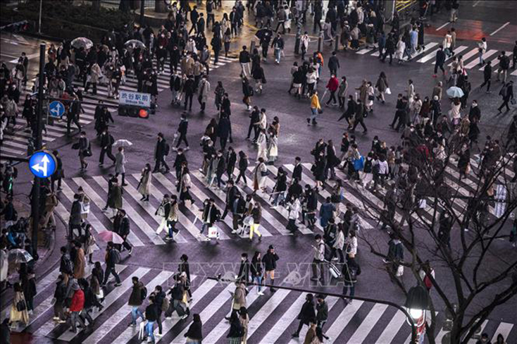 Người dân di chuyển trên đường phố tại Tokyo, Nhật Bản. Ảnh: AFP/TTXVN