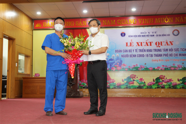 Bác sĩ Nhân đại diện đoàn nhận hoa từ ông Vũ Đại Thắng, Bí thư Tỉnh ủy Quảng Bình.