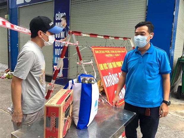 Công đoàn Thành đoàn Thành phố Hồ Chí Minh trao quà hỗ trợ cho người lao động trong khu phong tỏa, cách ly. (Ảnh: Thanh Vũ/TTXVN)