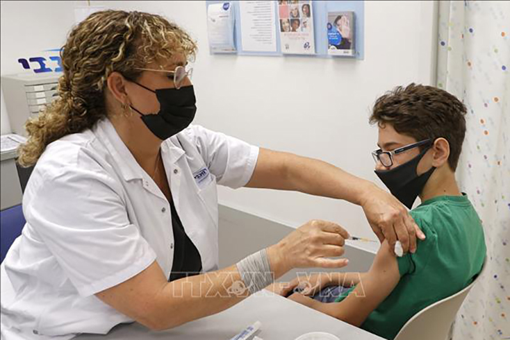  Nhân viên y tế tiêm vaccine ngừa COVID-19 cho trẻ em tại Tel Aviv, Israel. Ảnh: AFP/TTXVN