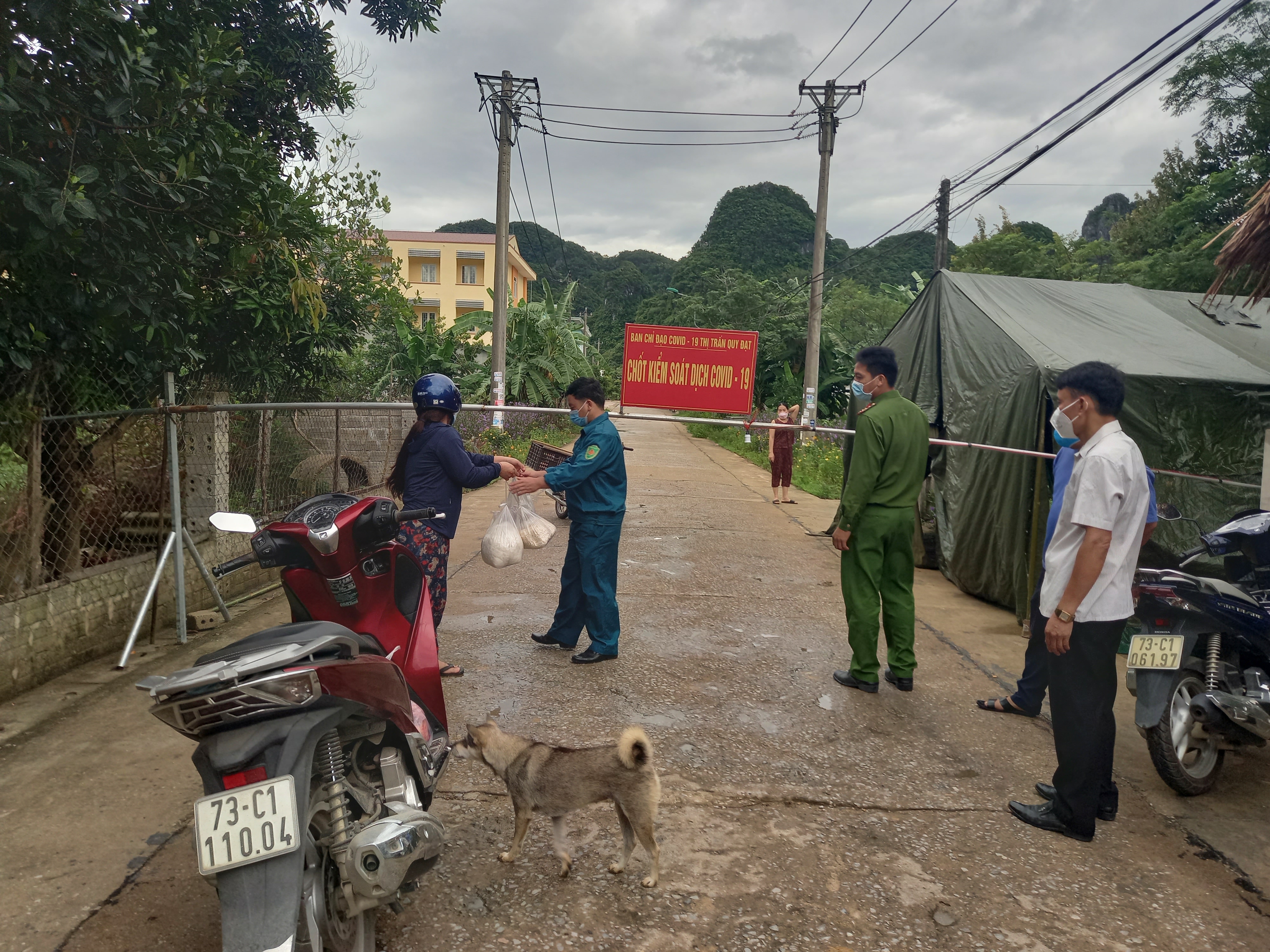 Người dân chuyển thức ăn cho người thân trong khu giãn cách qua lực lượng trực chốt kiểm soát dịch bệnh trong thời điểm giãn cách xã hôi..