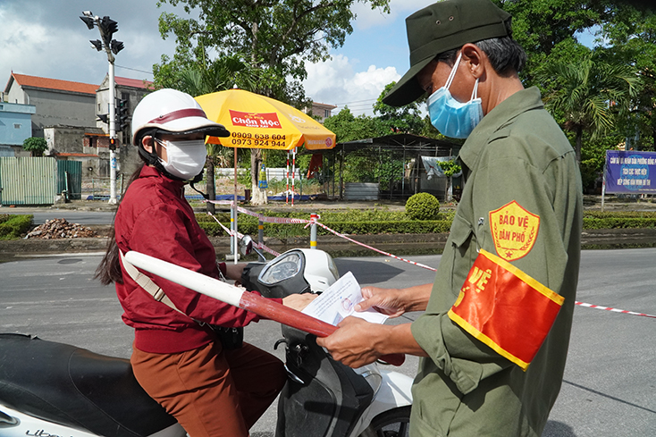 Lực lượng chức năng kiểm tra giấy đi đường của người dân khi qua chốt. 