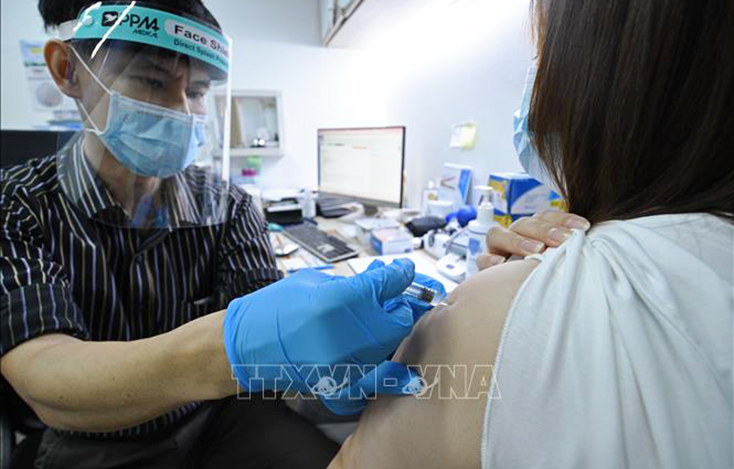 Nhân viên y tế tiêm vaccine phòng COVID-19 cho người dân tại Singapore. Ảnh: THX/TTXVN