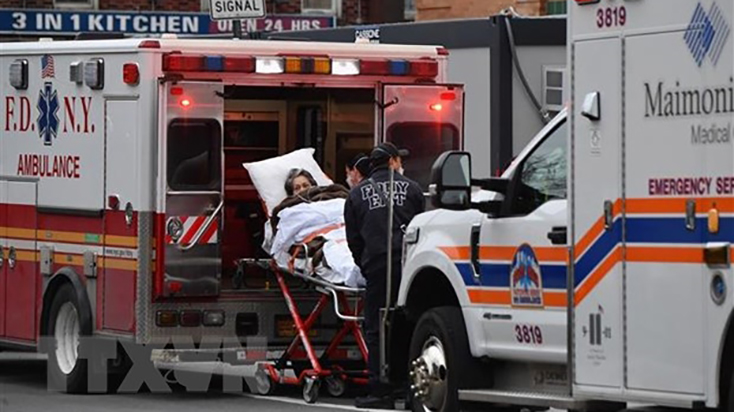Nhân viên y tế chuyển bệnh nhân COVID-19 tới trung tâm y tế tại New York, Mỹ. (Ảnh: AFP/ TTXVN)