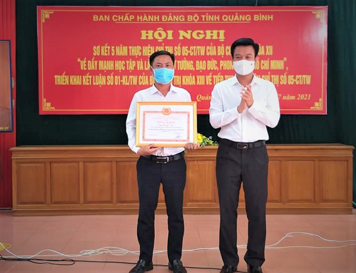  Lãnh đạo huyện Quảng Ninh trao bằng khen của Ban Thường vụ Tỉnh ủy cho anh Hoàng Văn Hào.