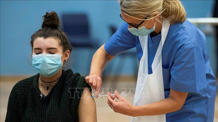 Nhân viên y tế tiêm vaccine ngừa COVID-19 cho người trẻ tuổi ở London, Anh. Ảnh: Getty Images/TTXVN