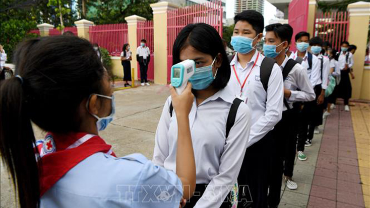   Kiểm tra thân nhiệt để phòng dịch COVID-19 tại một trường học ở Phnom Penh, Campuchia. Ảnh: AFP/TTXVN