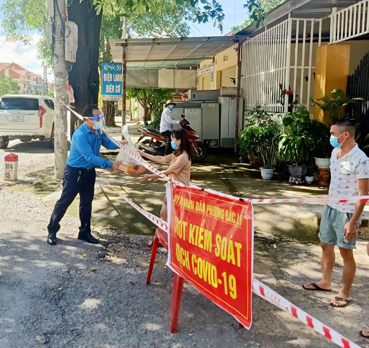 Đại diện lãnh đạo Công đoàn ngành Công thương Quảng Bình trao hỗ trợ lương thực cho các công nhân, lao động tại chốt kiểm soát dịch Covid-19 phường Bắc Lý (TP. Đồng Hới).