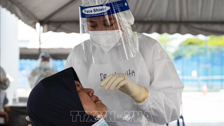 Nhân viên y tế lấy mẫu xét nghiệm COVID-19 cho người dân tại Kuala Lumpur, Malaysia . Ảnh: AFP/TTXVN
