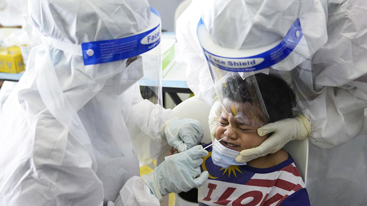 Nhân viên y tế lấy mẫu xét nghiệm COVID-19 cho một cậu bé tại Kuala Lumpur, Malaysia. Ảnh: AP