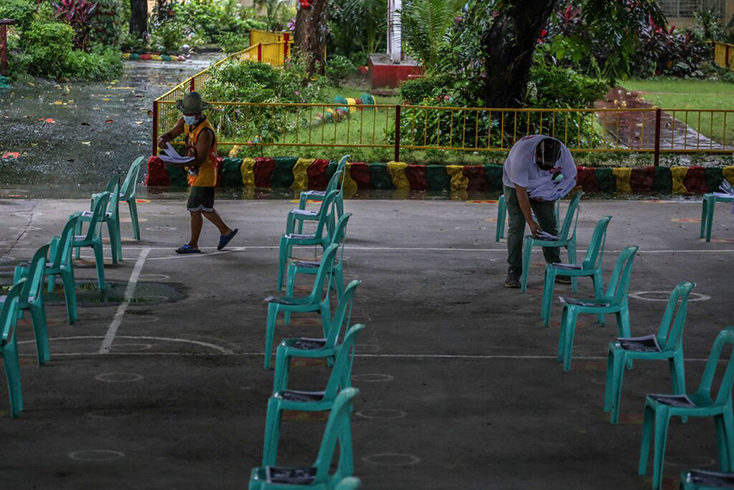 Giáo viên và tình nguyện viên phát tài liệu học tập cho phụ huynh đến nhận tại một trường học ở thành phố Quezon, gần Manila. Ảnh: Getty
