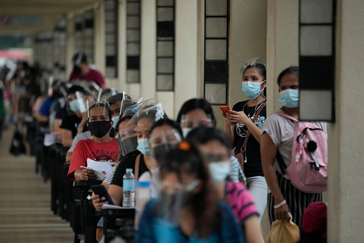 Người dân xếp hàng chờ đợi tại một trung tâm tiêm chủng ở Manila. Ảnh: AP