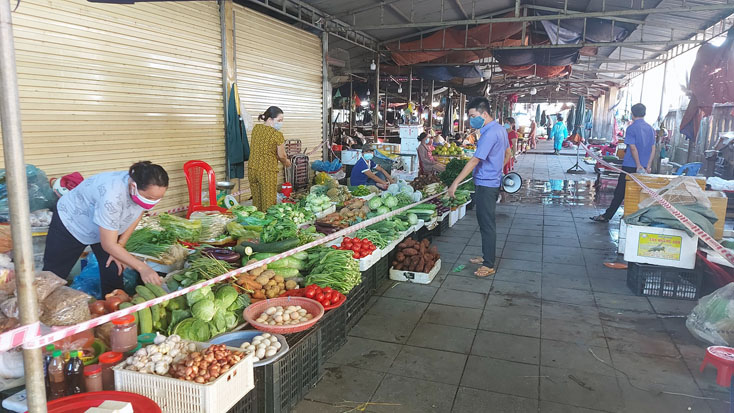 Tại chợ Ga (Nam Lý), các gian hàng được giăng dây giữ khoảng cách giữa khách hàng với người bán hàng theo quy định