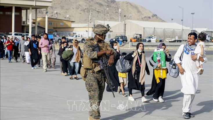 Binh sĩ Mỹ hỗ trợ người dân sơ tán khỏi Afghanistan, tại sân bay quốc tế Hamid Karzai ở Kabul ngày 18-8-2021. Ảnh: AFP/TTXVN