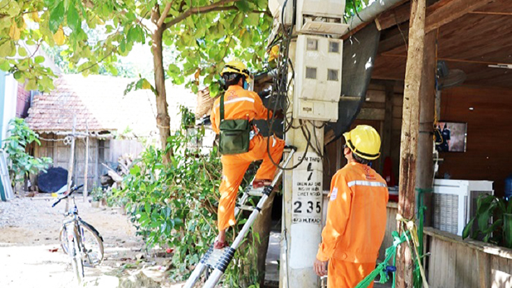Công nhân PC Quảng Bình thay mới công tơ điện cho khách hàng.