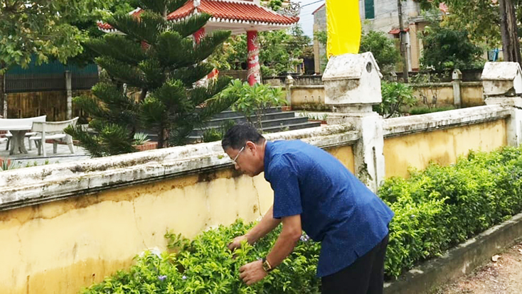 Ông Trần Đức Huệ chăm sóc đường hoa trong khu dân cư.