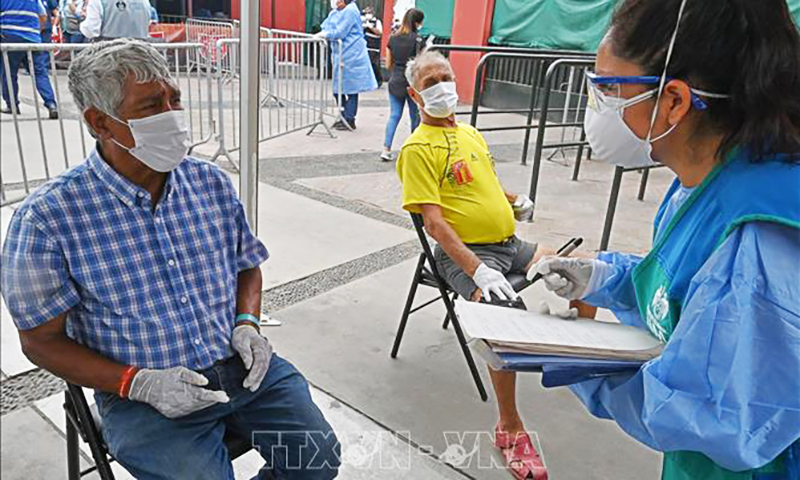 Nhân viên y tế lấy mẫu xét nghiệm COVID-19 cho người dân tại Lima, Peru. Ảnh tư liệu: AFP/TTXVN