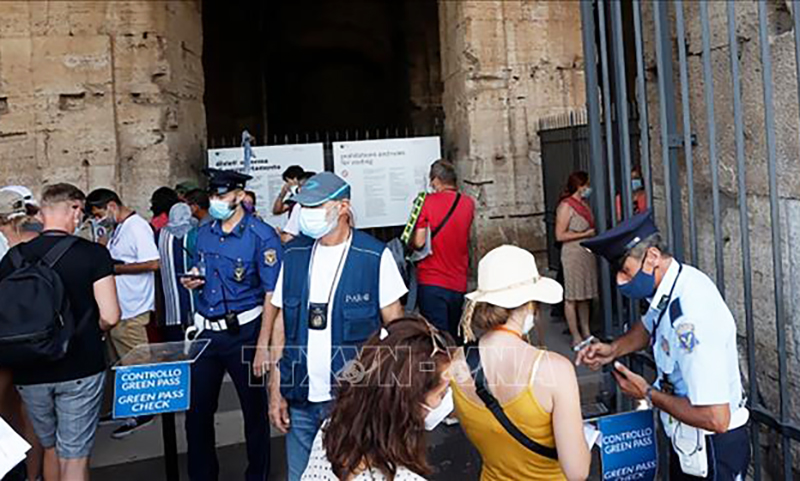 Nhân viên an ninh kiểm tra thẻ xanh của du khách tại cửa vào Đấu trường La Mã tại Rome, Italy. Ảnh: AP/TTXVN