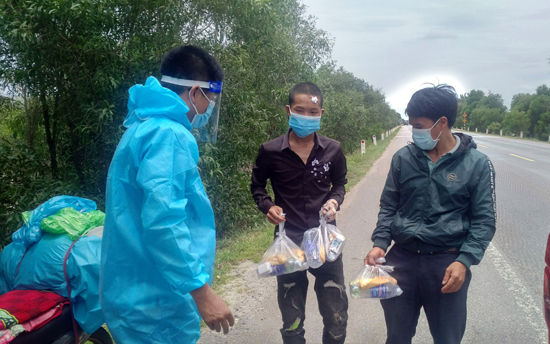 Phóng viên Báo Quảng Bình trao quà cho người dân về quê tránh dịch đi qua địa phận tỉnh