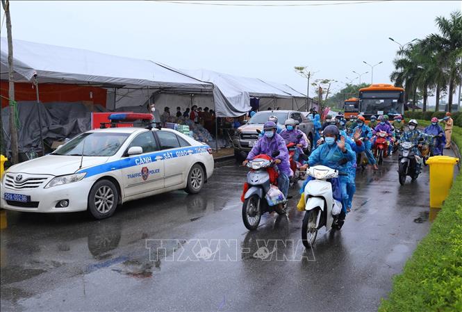  Lực lượng chức năng hỗ trợ người dân di chuyển khỏi điểm trung chuyển huyện Phú Xuyên để tiếp tục hành trình về quê, chiều 9-10. Ảnh minh họa: Hoàng Hiếu/TTXVN