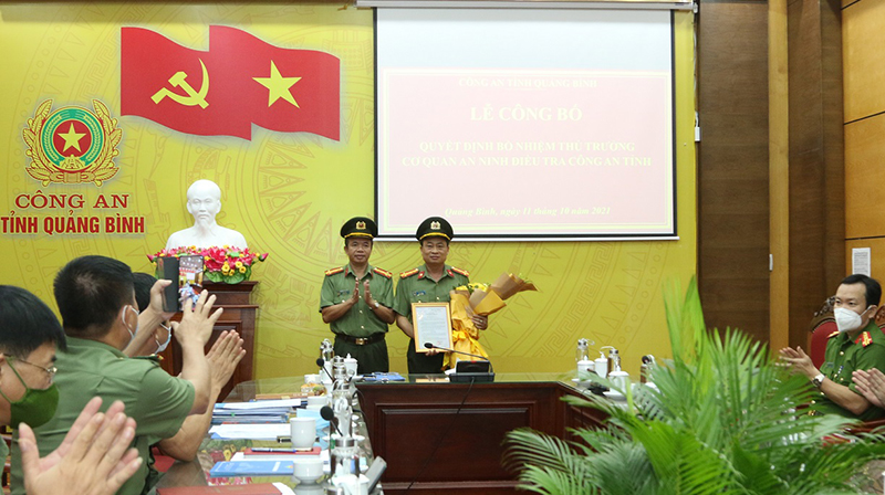 Thừa ủy quyền lãnh đạo Bộ Công an, Đại tá Nguyễn Tiến Nam, Giám đốc Công an tỉnh trao quyết định và tặng hoa chúc mừng Thủ trưởng Cơ quan An ninh điều tra Công an tỉnh.