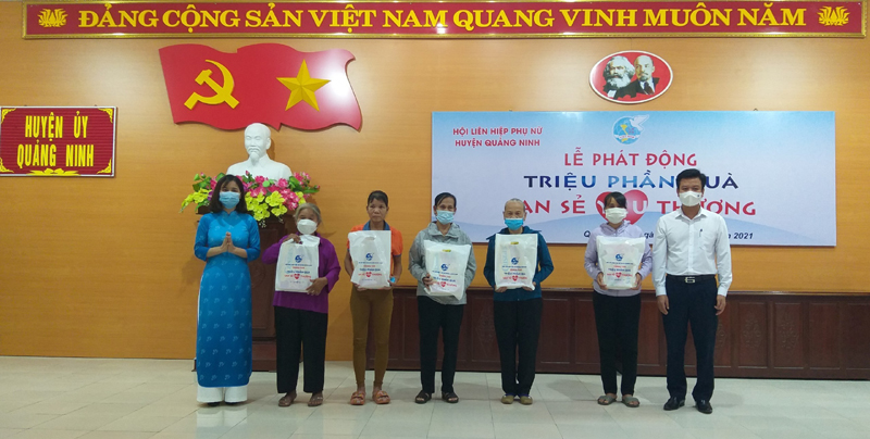 Đại diện lãnh đạo huyện Quảng Ninh và Hội LHPN tỉnh tặng quà cho phụ nữ có hoàn cảnh khó khăn.